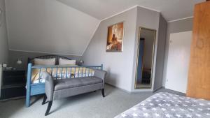 ein Schlafzimmer mit einem Bett, einem Stuhl und einem Spiegel in der Unterkunft Villa Luba in Ostseebad Koserow