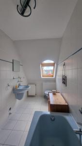 ein Badezimmer mit einer blauen Badewanne und einem Waschbecken in der Unterkunft Villa Luba in Ostseebad Koserow + 37 Fotos