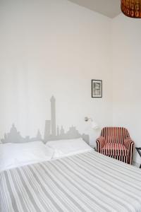a bedroom with a bed and a chair at A Casa di Lu Na in Bologna