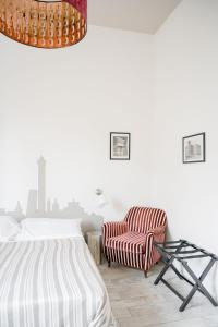 a bedroom with a bed and a chair at A Casa di Lu Na in Bologna