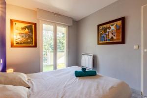 una camera da letto con un letto bianco e una finestra di Le nid montois - centre - parking - balcon - wifi - lave linge et vaisselle a Mont-de-Marsan