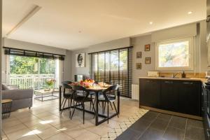 una cucina e un soggiorno con tavolo e sedie di Le nid montois - centre - parking - balcon - wifi - lave linge et vaisselle a Mont-de-Marsan
