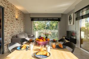 un tavolo da pranzo con una ciotola di frutta sopra di Le nid montois - centre - parking - balcon - wifi - lave linge et vaisselle a Mont-de-Marsan Altre 12 foto