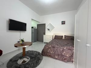 a bedroom with a bed and a table and a tv at Al Karama Studio in Abu Dhabi