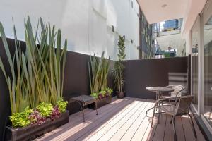 balcone con tavolo, sedie e piante di Chic 2BR Condo in Condesa steps from Parque Mexico a Città del Messico