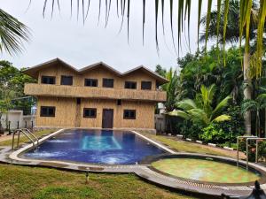 a house with a large swimming pool in front of it at The Exotic Aura Resort in Pondicherry