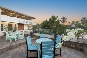 un patio con sedie blu e un tavolo e un ristorante di Echor Kia - A Boutique Hotel Anjuna Goa ad Anjuna