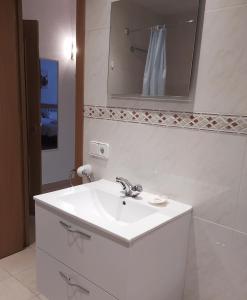 a white bathroom with a sink and a mirror at Apartaments Els Avets in Pas de la Casa +52 photos