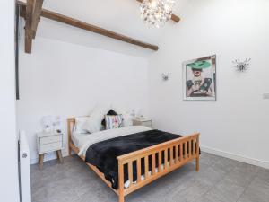 a bedroom with a bed and a chandelier at Ty'n Lon Farm in Pwllheli