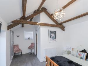 a bedroom with a bed and a ceiling with beams at Ty'n Lon Farm in Pwllheli