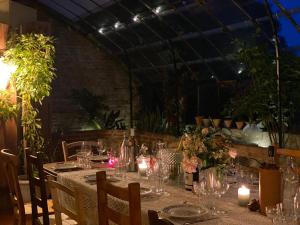 Una mesa con velas y vasos en un invernadero. en Le Baccara Lodge, véritable maison de famille avec piscine et parc, en Arengosse 76 fotos más