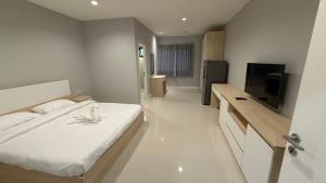 a bedroom with a bed and a flat screen tv at Nene Apartment in Ban Bang Talat