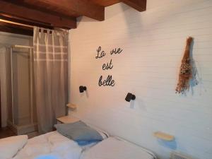 um quarto com uma parede branca onde se lê: "Comemos justiça?" em Julie's House em Chanéac