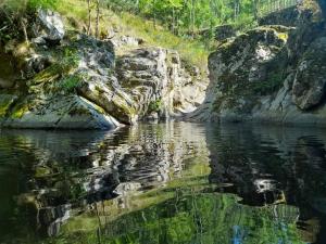 um corpo de água com algumas rochas e árvores em Julie's House em Chanéac mais 9 fotografias