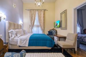 una camera da letto con un letto, una sedia e una finestra di Theodoros Kolokotronis - Polimnia a Nauplia