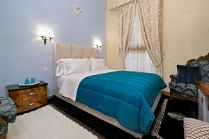 una camera da letto con un letto con una coperta blu e una finestra di Theodoros Kolokotronis - Polimnia a Nauplia