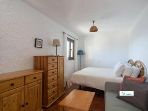 a bedroom with a bed and a dresser and a couch at Living Artenara - EARTH Adults Only in Artenara