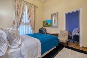 una camera da letto con un letto blu e una finestra di Theodoros Kolokotronis - Polimnia a Nauplia