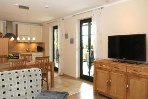 een keuken en woonkamer met een televisie op een houten kast bij Ferienwohnung Sonnenhang-Hartmann in Olsberg