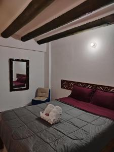 a bedroom with a bed and a chair and a mirror at Villa Girasol in Villa de Leyva