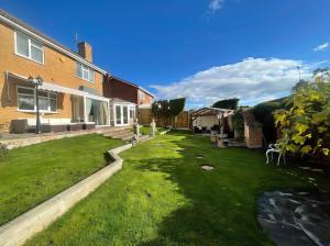a backyard of a house with a grass yard at Ivy's End in Loughborough