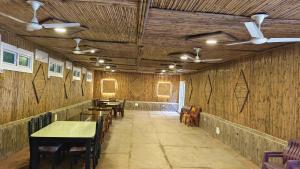 comedor con mesas, sillas y ventiladores de techo en The Exotic Aura Resort, en Pondicherry