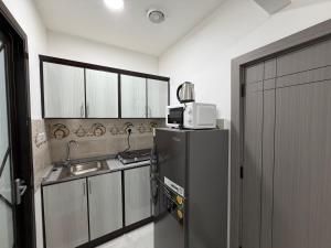 a kitchen with a black refrigerator and a sink at Al Karama Studio in Abu Dhabi