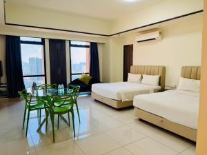 una camera d'albergo con due letti e un tavolo in vetro di Maju Suites Berjaya Times Square a Gua Sai