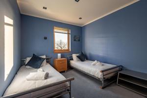 zwei Betten in einem Zimmer mit blauen Wänden in der Unterkunft Homeview - Elie & Earlsferry in Elie