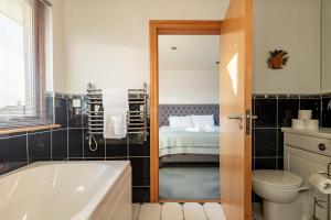 ein Badezimmer mit Badewanne und Toilette und ein Bett in der Unterkunft Homeview - Elie & Earlsferry in Elie + 54 Fotos