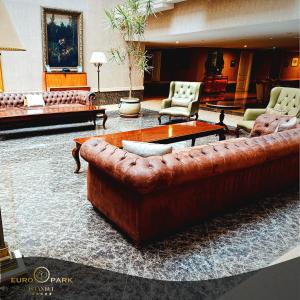 a living room with a brown leather couch and chairs at Euro Park Otel in Istanbul +104 photos