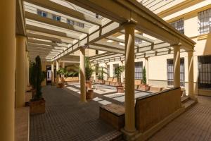 ein leeres Gebäude mit einer hölzernen Pergola mit Topfpflanzen in der Unterkunft Conde Center Premium Suites in Sevilla