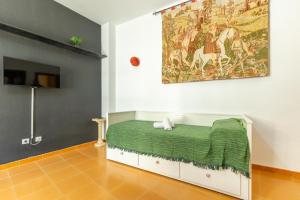 ein Schlafzimmer mit einem Bett mit einer grünen Decke in der Unterkunft Conde Center Premium Suites in Sevilla