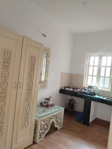 a kitchen with a counter and a table in a room at 1Bhk URA Apartment Candolim in Candolim