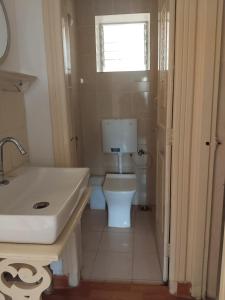 a bathroom with a toilet and a sink and a window at 1Bhk URA Apartment Candolim in Candolim +13 photos