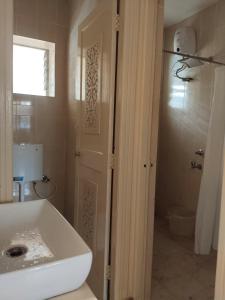 a bathroom with a white sink and a toilet at 1Bhk URA Apartment Candolim in Candolim