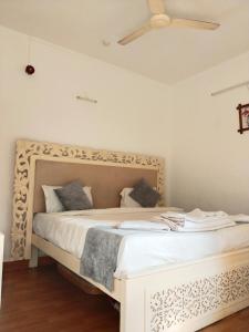 a bed in a room with a ceiling fan at 1Bhk URA Apartment Candolim in Candolim