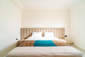 1 dormitorio con 1 cama grande y paredes blancas en Appart Atlas, en Marrakech