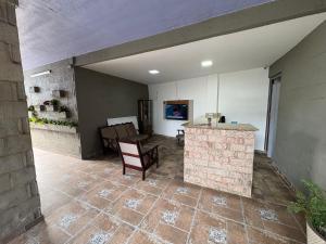 a living room with a stone counter and a table at Recanto Praia Grande in Arraial do Cabo