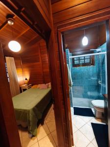 een slaapkamer met een bed en een badkamer met een douche bij Quarto com cama de casal - Florianópolis in Florianópolis