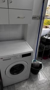 a white washing machine in a kitchen with a mop at The Travellers Den in Matosinhos