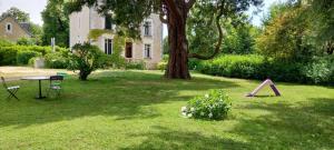 a yard with a table and chairs and a tree at CHANTOISEAU in Ligueil