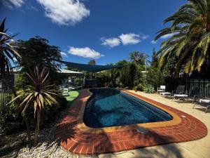 a swimming pool in the backyard of a house at Sunrise Motel in Barooga