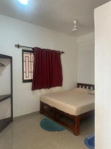 een slaapkamer met een bed en een rood raam bij Laxmi house in Arambol