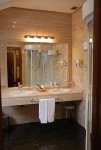a bathroom with a sink and a large mirror at Hostal Los 5 Pinos in Madrid