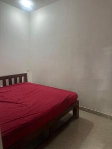 een slaapkamer met een bed met een rode deken bij Laxmi house in Arambol +10 foto's