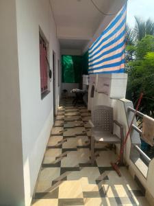 een veranda met een stoel en een vlag op een huis bij Laxmi house in Arambol