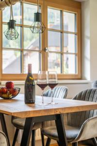 two glasses of wine sitting on a wooden table at Dorfplatzl Suite in Hohentauern +17 photos