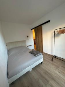 a bedroom with a white bed and a wooden floor at Magnifique appartement à 300m des plages à Port Frejus in Fréjus