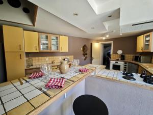 a kitchen with a table with wine glasses on it at Charmante maison de village 8 personnes avec parking gratuit in Tourreilles